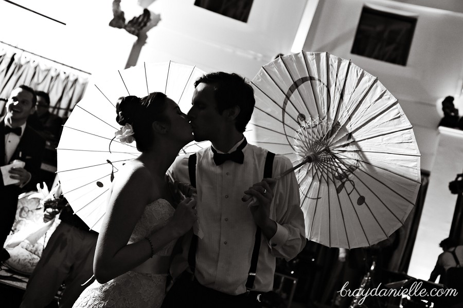 Bride and groom kissing with parasols umbrellas, wedding by Bray Danielle Photography