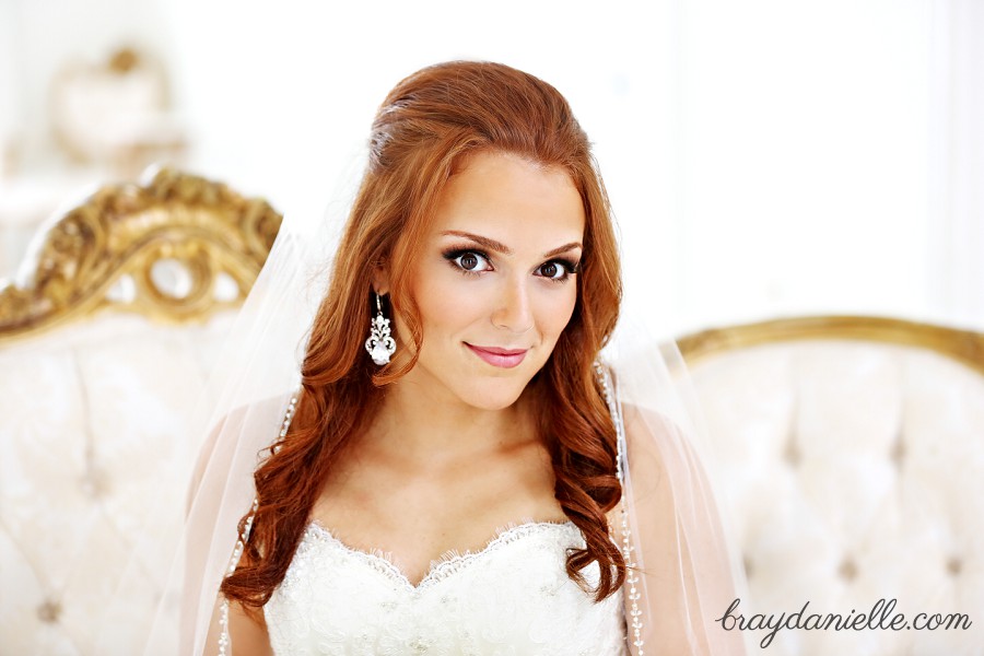 bride sitting on gold and white couch with red hair by Bray Danielle Photography 