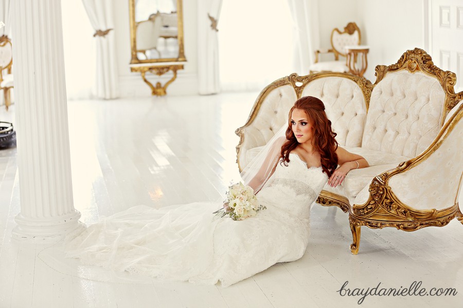 bride sitting on floor leaning on white and gold couch by Bray Danielle Photography 