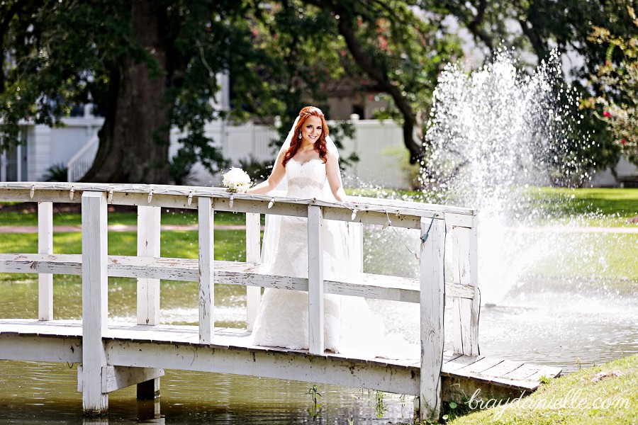 bride on bridge with a fountain behind her by Bray Danielle Photography 