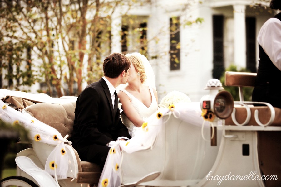 bride and groom kissing in carriage