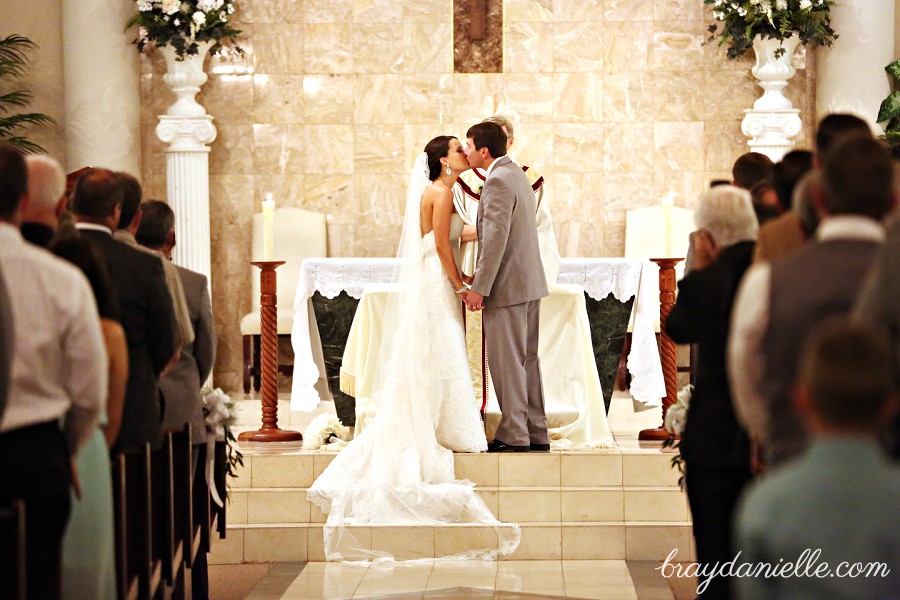 bride and groom first kiss inside of church