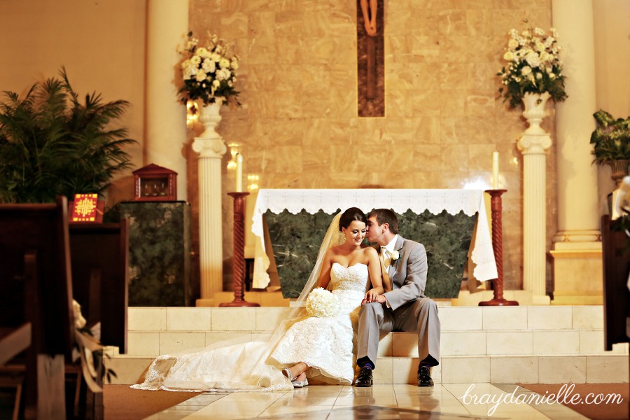 Bride and groom sitting on steps in church