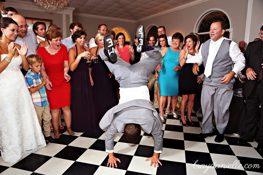 groom doing handstand at reception