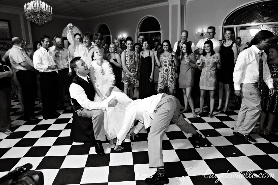 Funny photo of groom getting the garter off the bride