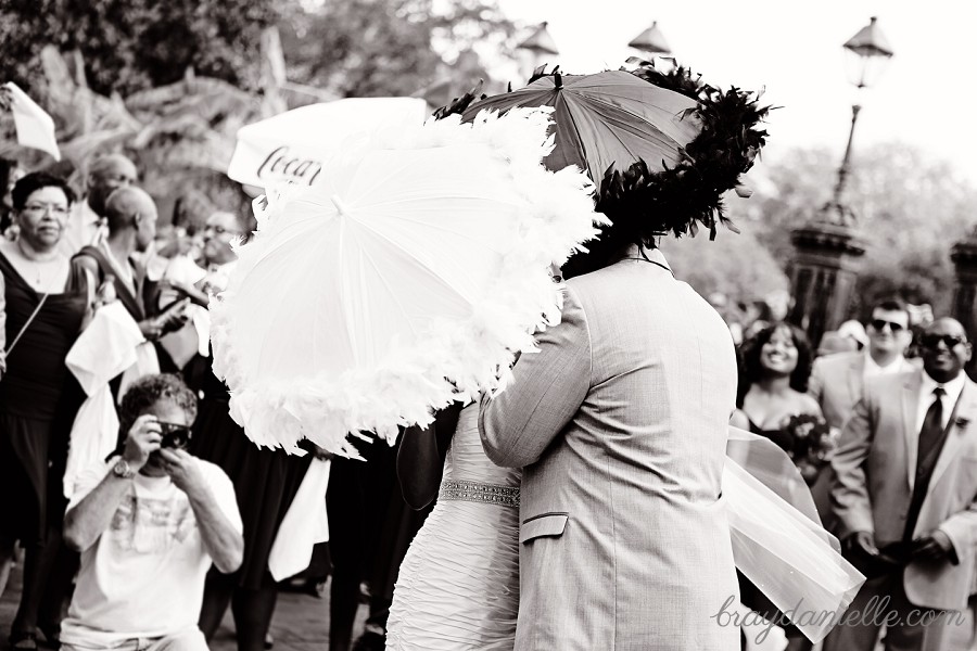 Bride and groom kissing behind parosels