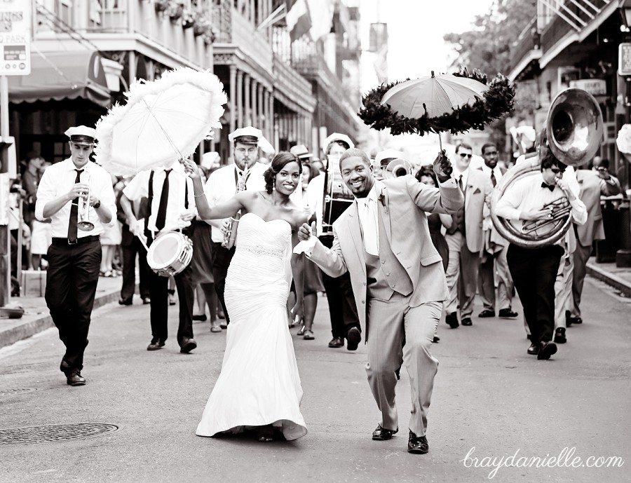 Bride and groom walking down the street with jazz band